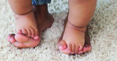baby and parent's feet on rug