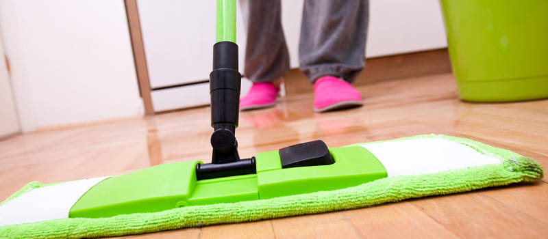 person cleaning hardwood floor