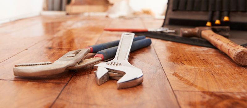 Spanner and pliers on wooden floor